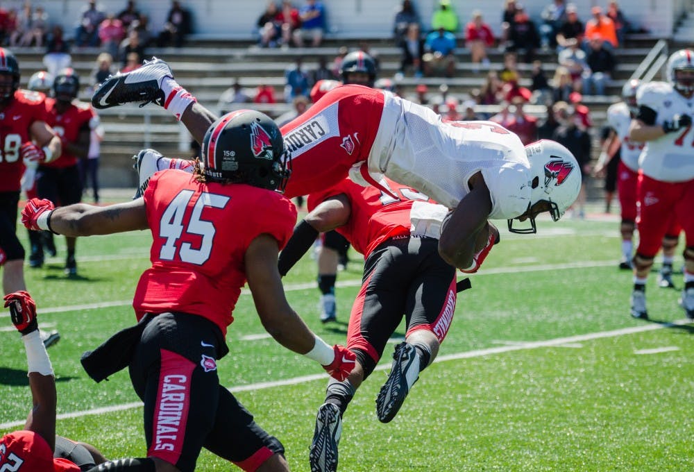 Junior Teddy Williamson is knocked in the air by the defense at the spring game on April 23 at Scheumann Stadium. DN PHOTO KELLEN HAZELIP