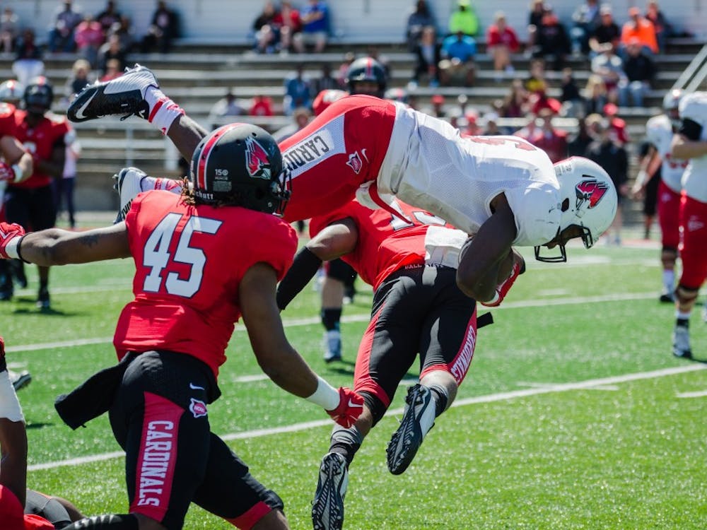 Junior Teddy Williamson is knocked in the air by the defense at the spring game on April 23 at Scheumann Stadium. DN PHOTO KELLEN HAZELIP