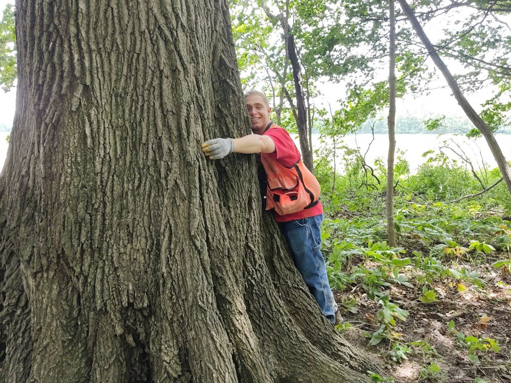 Ball State senior Steve Doll hugs a tree during his and the Department of Biology&#x27;s field work. Doll is a Udall Scholarship awardee and the President of the Ball State Wildlife Society. John Taylor, Photo Provided