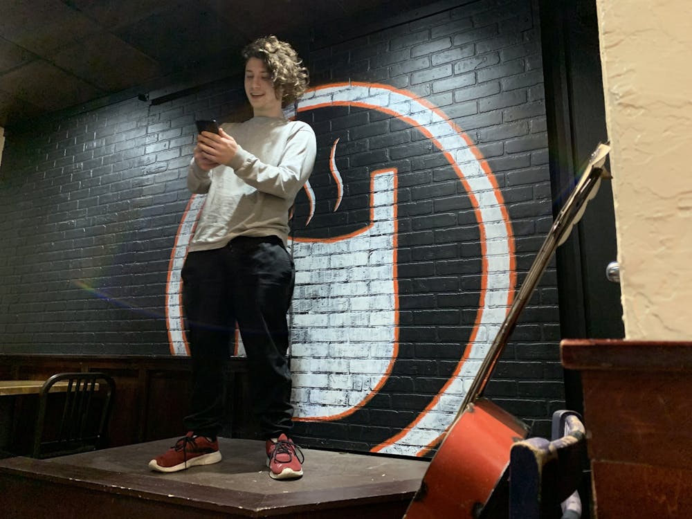 Tim Stewart reads the first poem he has ever written off of his phone Jan. 26, 2020, on stage at Cuplets at The Cup. Stewart said his goal for the new year is to try something new every month, so he made poetry his January activity. Taylor Smith, DN