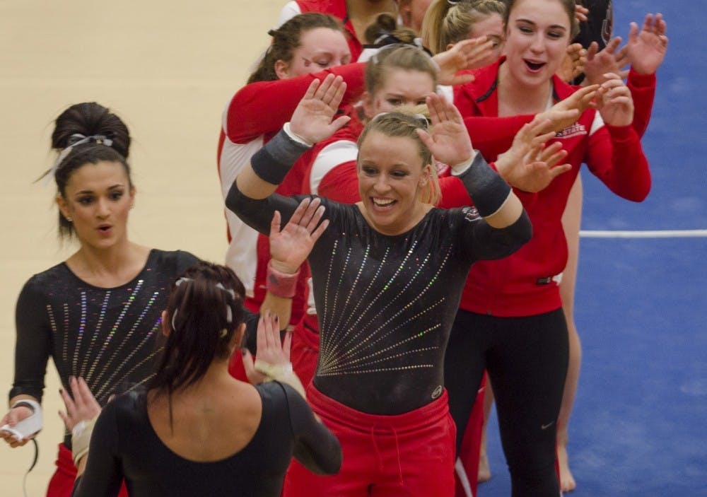 Sophomore Kayla Beckler goes to high-five her teammates after competing on the vault in the match against Northern Illinois on Feb. 27, 2015, at Irving Gymnasium. DN PHOTO BREANNA DAUGHERTY