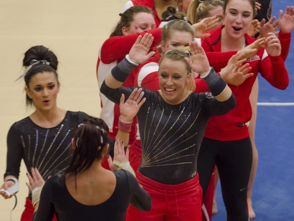 Sophomore Kayla Beckler goes to high-five her teammates after competing on the vault in the match against Northern Illinois on Feb. 27, 2015, at Irving Gymnasium. DN PHOTO BREANNA DAUGHERTY