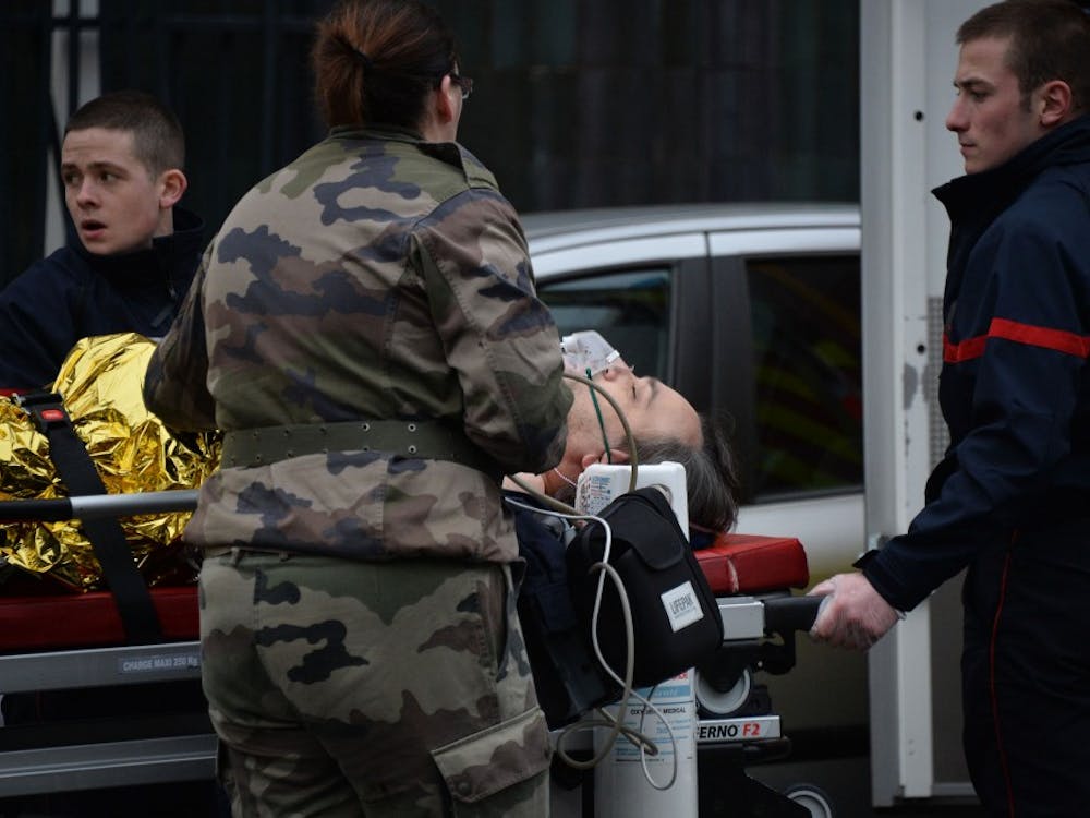 Paramedics wheel a victim to an ambulance on Jan. 7, 2015 in Paris, France, after an attack where masked gunmen attacked the Paris office of French satirical magazine Charlie Hebdo, killing 12 people and injuring seven. At least two masked attackers opened fire with assault rifles in the office and exchanged shots with police in the street outside before escaping by car. President Hollande said there was no doubt it had been a terrorist attack 'of exceptional barbarity.' A major police operation is under way in the Paris area to catch the killers. (Panoramic/Zuma Press/TNS) 