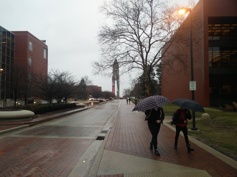 <p>Ball State students walk with umbrellas 5 p.m. Thursday on McKinley Avenue right outside Bracken Library. National Weather Service has issued a flood watch and wind advisory in effect until Friday morning. <strong>Rohith Rao, DN</strong></p>