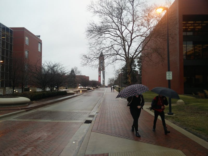 Ball State students walk with umbrellas 5 p.m. Thursday on McKinley Avenue right outside Bracken Library. National Weather Service has issued a flood watch and wind advisory in effect until Friday morning. Rohith Rao, DN