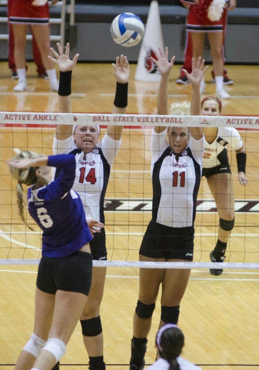 Redshirt middle blocker junior Kelly Hopkins and junior middle blocker Amanda Raker attempt to block a shot from a Western Illinois player on Aug. 29 at Worthen Arena. DN PHOTO BREANNA DAUGHERTY
