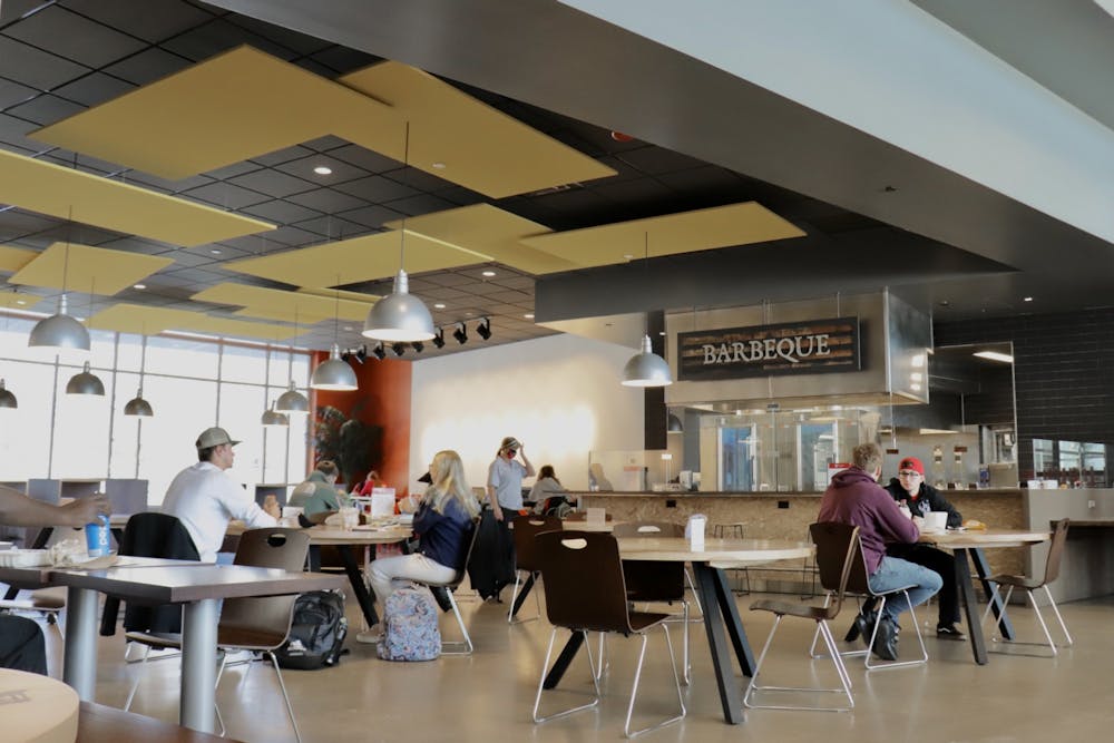 Students eat food by the barbecue station Feb. 2, 2021 at North Dining Hall. With new COVID-19 precautions, dining halls across campus have spaced out their tables to allow space for social distancing. Rylan Capper, DN
