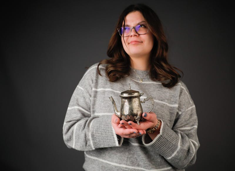 Second-year marketing major Elizabeth Pavey holds an old family heirloom on Jan. 14 in the Arts and Journalism Building. Pavey believes that just because you let go of physical possessions does not mean the memories are lost. Andrew Berger, DN 

