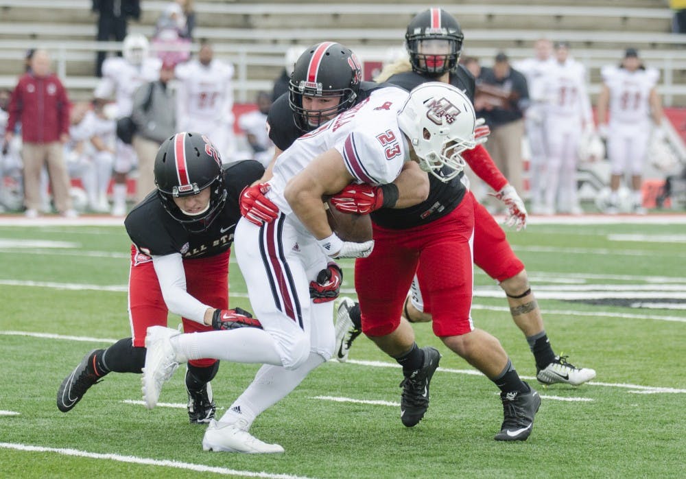 Members of the Ball State defensive line attempt to tackle a University of Massachusetts player during the game on Oct. 31 at Scheumann Stadium. DN PHOTO BREANNA DAUGHERTY