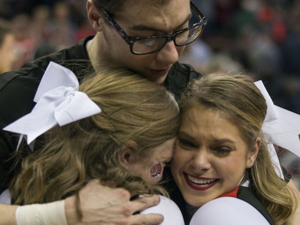 Members of the Ball State cheerleading team embrace after the 74-70 loss against Akron in the MAC semifinal game March 10 at Quicken Loans Arena in Cleveland, Ohio. Breanna Daugherty // DN