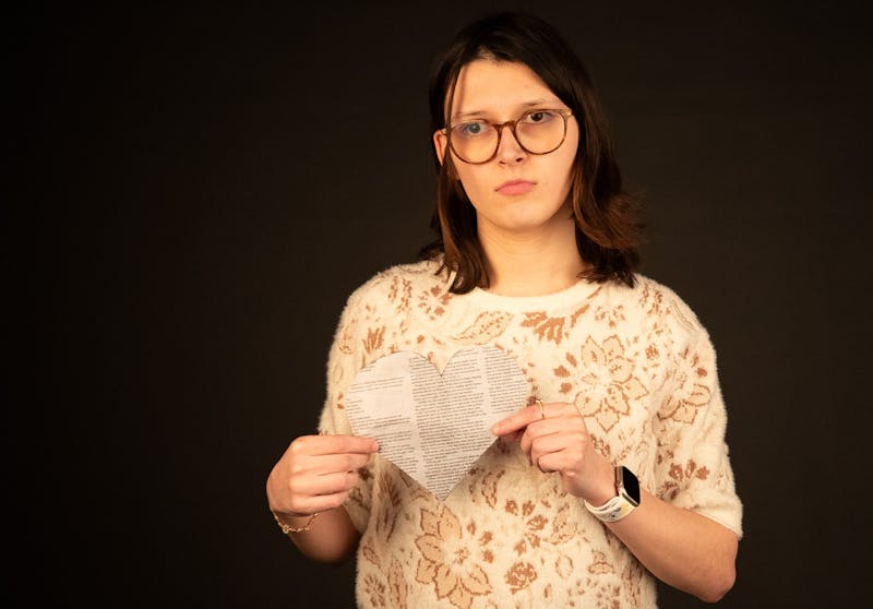 Second-year journalism major Kate Hill holds a newspaper heart for a portrait Jan. 27 at the Arts and Journalism Building. Hill believes that empathy is the cornerstone of good journalism. LJ Barnes, DN 