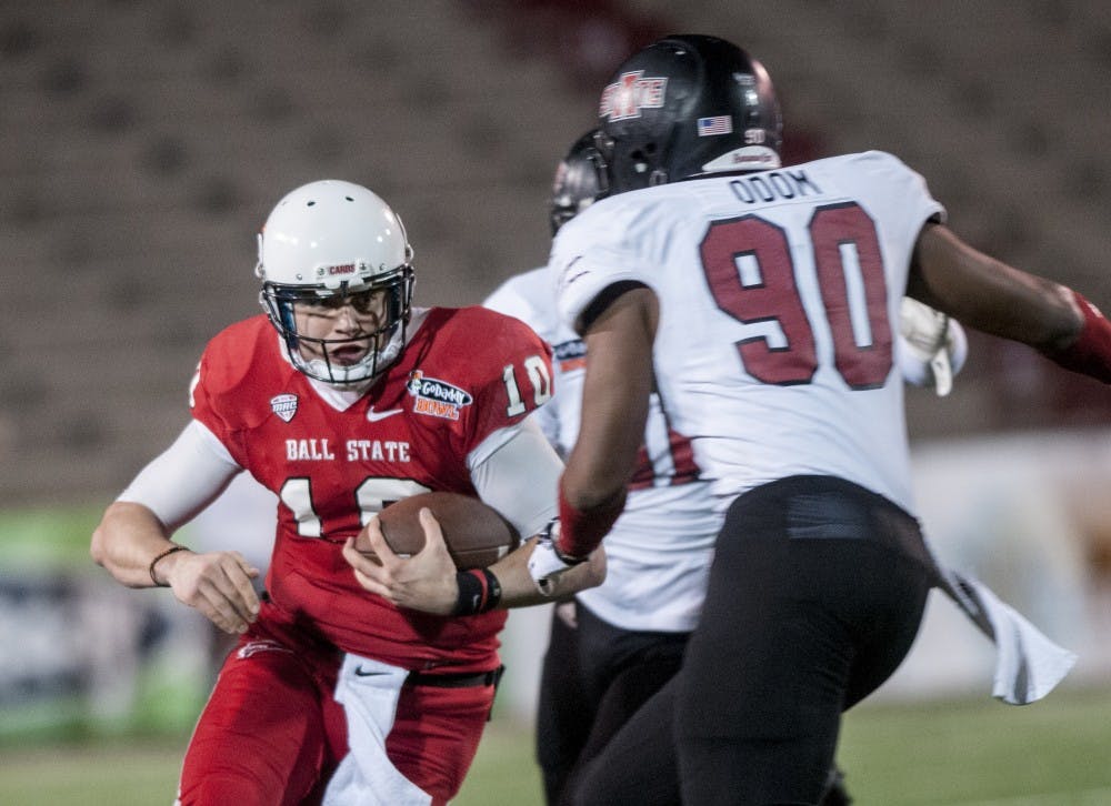 Senior quarterback Keith Wenning attempts to make a push downfield on a quarterback keeper. DN PHOTO JONATHAN MIKSANEK