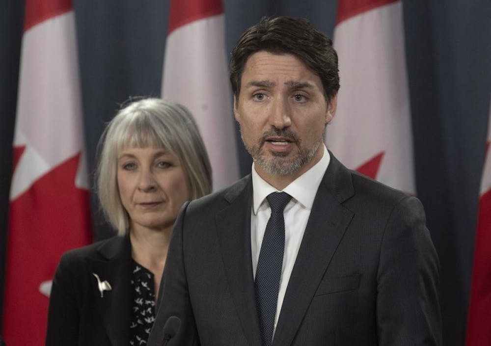 <p>Minister of Health Patty Hajdu looks on as Prime Minister Justin Trudeau speaks during a news conference in Ottawa, Wednesday March 11, 2020. Canada is announcing $1 billion ($730 million) in funding to help health-care workers cope with the increasing number of new cases of coronavirus and to help Canadian workers who are forced to isolate themselves. <strong>(Adrian Wyld/The Canadian Press via AP)</strong></p>