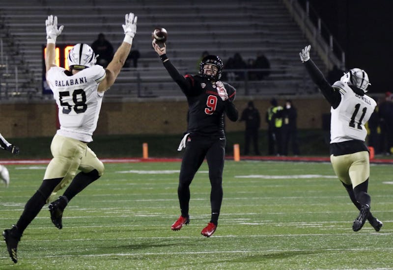 Ball State redshirt sophomore quarterback Drew Plitt passes the ball to a teammate while Western Michigan defenders try to knock the ball out of the air during the Cardinals' game against the Broncos Nov. 13, 2018, at Scheumann Stadium. Ball State won 42-41 in overtime on senior night. Paige Grider, DN