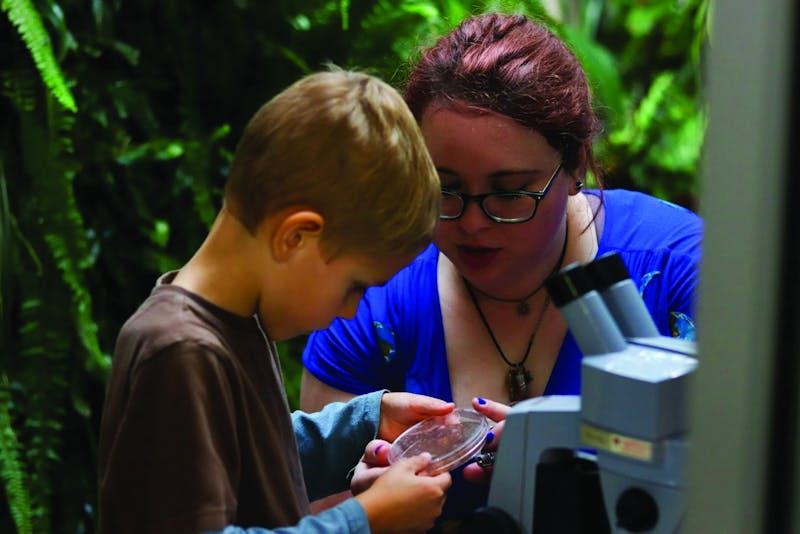 Erica Forstater, environmental education program coordinator, teaches a young child during the Rinard Orchid Greenouse's Halloween program. The Rinard Orchid Greenhouse hosts events the second Saturday of each month to educate the Muncie community about the environment. Erica Forstater, Photo Provided 