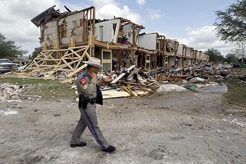 Department of Public Safety Sgt. Jason Reyes walks by an apartment complex on April 21, near the West Fertilizer plant that was destroyed in the explosion in West, Texas. The blast killed 14 people and injured about 200 more. MCT PHOTO