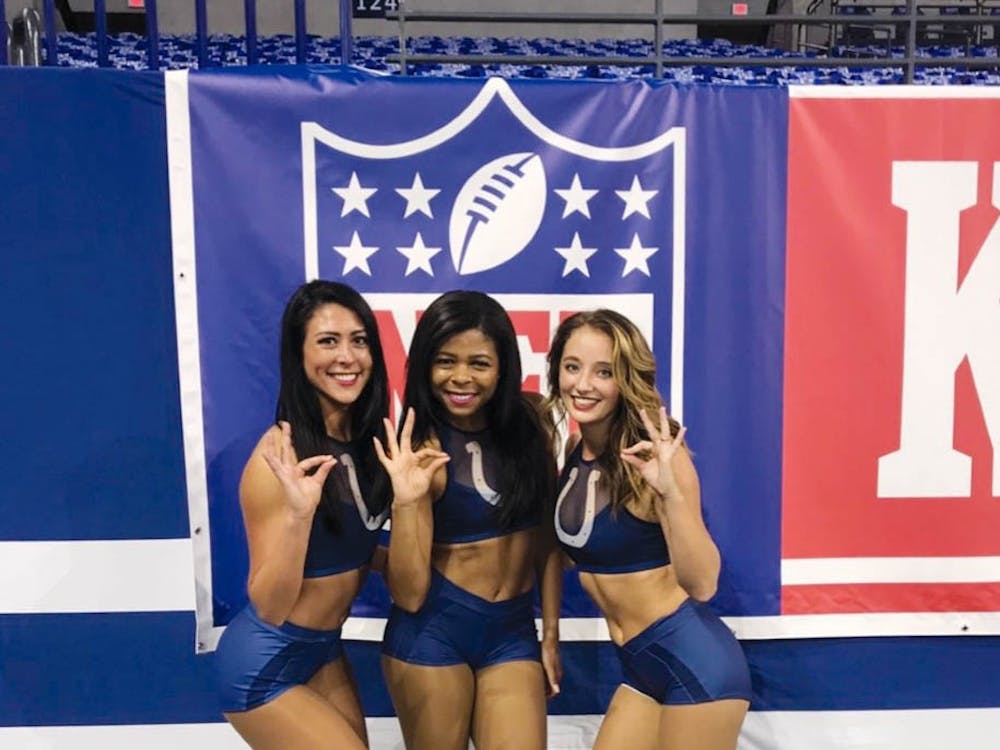 At an Indianapolis Colts game Sept. 9, 2018, former Indianapolis Colts cheerleaders Anne Cardimen (left), Ambria Ollie (middle) and Sarah Gilliom (right), strike a pose and sign Ball State’s ‘Chirp, chirp.’ Both Cardimen and Ollie are Ball State alumni and former dancers for Code Red Dance Team. Ambria Ollie, Photo Provided