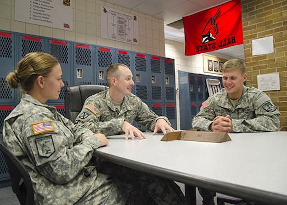 ROTC members Carolyn Bell, Wesley Jones and Michael McAllister sit around their conference table in the ROTC meeting area. During training, conversations about current events such as Syria are held here so that soldiers can think about how to lead fellow soldiers in certain situations. DN PHOTO COREY OHLENKAMP