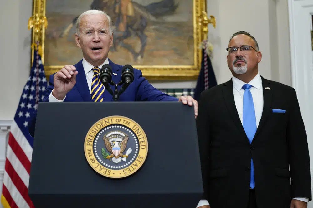 President Joe Biden speaks about student loan debt forgiveness in the Roosevelt Room of the White House, on Aug. 24, 2022, in Washington. Education Secretary Miguel Cardona listens at right. The White House is moving forward with a proposal that would lower student debt payments for millions of Americans now and in the future, offering a new route to repay federal loans under far more generous terms. Education Department officials on Tuesday, Jan. 10, 2023, called the new plan a “student loan safety net" that will prevent borrowers from getting overloaded with debt. (AP Photo/Evan Vucci, File)
