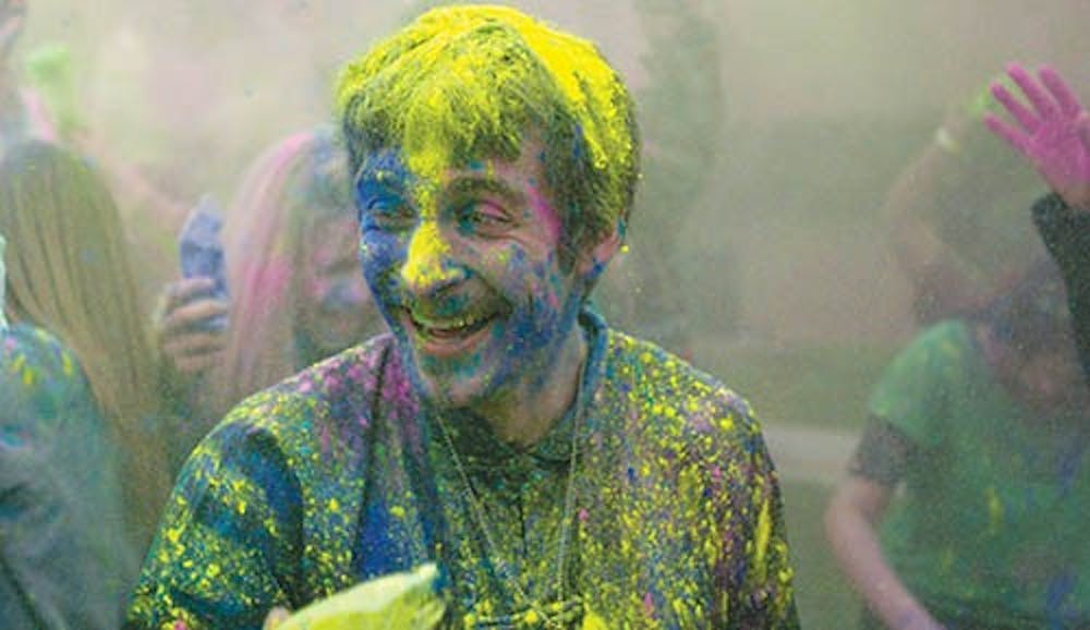 Senior sculpture major Nathan Ferrise laughs as he receives a blast of yellow chalk to his face during the Holi festival on April 19, 2013 at Noyer Complex. Holi is a Hindu celebration that honors the oncoming of spring, a time known to the Hindu people as a period of renewal. DN PHOTO RJ RICKER