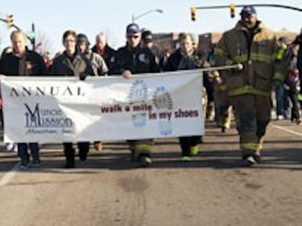 Firefighters lead the "Walk-A-Mile In My Shoes" march toward the Muncie Mission. This marks the eighth year of the march. DN PHOTO BOBBY ELLIS