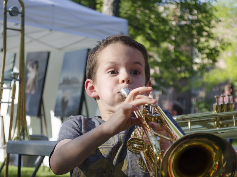 Noah Raymond, 6, plays the trumpet at the "Instrument Petting Zoo" at the Festival on the Green on June 14 at the Arts Terrace. DN PHOTO BREANNA DAUGHERTY 