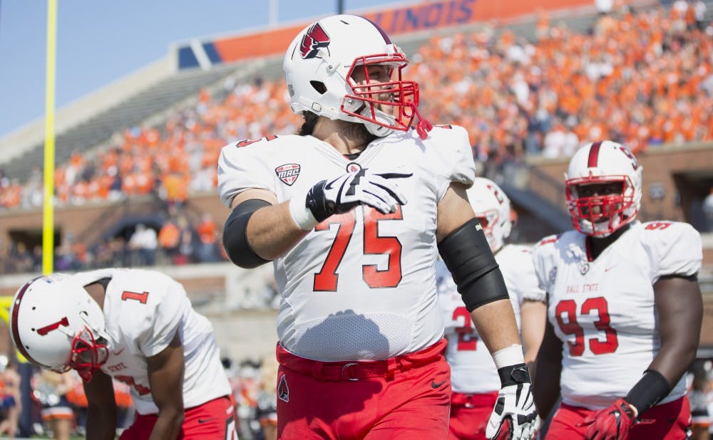 Ball State offensive lineman Vinnie Palazeti leads the team's captains onto the field before their match against the University of Illinois on Sept. 2. Robby General, DN File