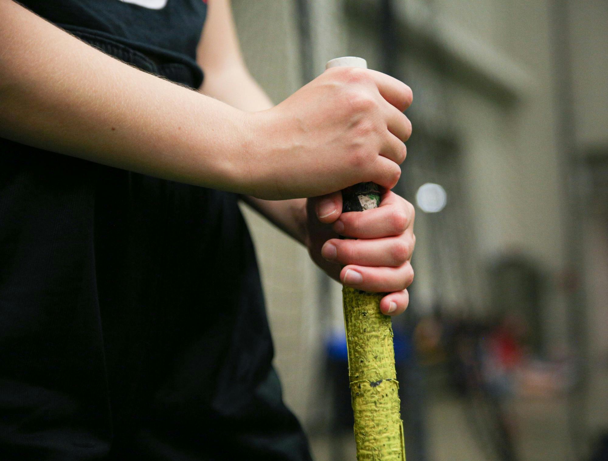 A Ball State Quadball player stands on the sidelines with their broom at Student and Wellness Recreation Center Sept. 6. Jacy Bradley, DN