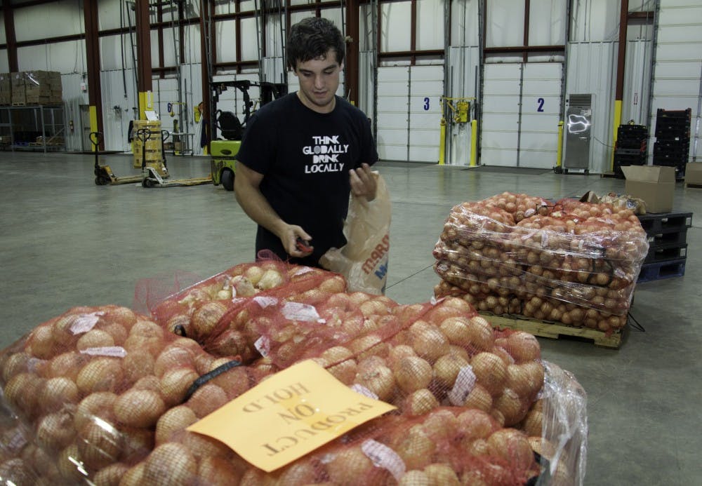 David Schellenberger packs onions at Second Harvest Foods in Muncie. Schellenberger packs food and cleans the facility for community service hours for his Fraternity and to fill his spare time. DN PHOTO RJ RICKER