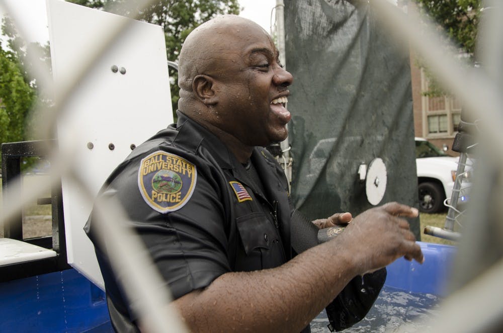 Officer Terrell Smith of the University Police Department laughs Friday afternoon after being dunked by bystanders during UPD’s “Dunk-a-Cop” Event. The proceeds from the event benefit the Special Olympics. © Ohlenkamp, 2013