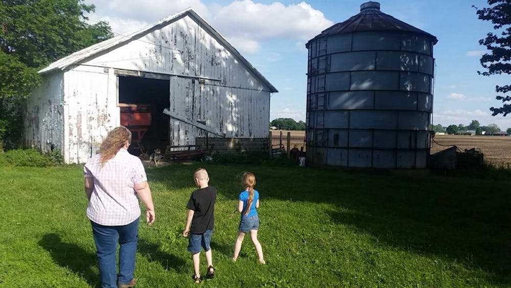 <p>Tana Pittsford walks to the family sheep barn with her grandchildren, Wyatt and Kaylee Pitsfords. The Pittsfords are a six-generation 4-H family from Yorktown, Ind. who participated at the Indiana State Fair this summer. <em>LAURA ARWOOD / </em><em>BSU JOURNALISM AT THE FAIR </em></p>