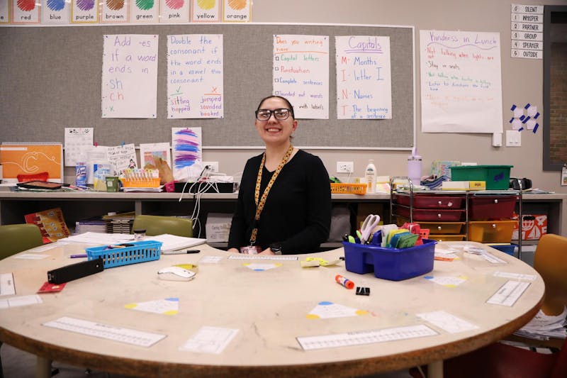  First-grade teacher Savannah Oliphant poses for a photo at one of the tables in her classroom Feb. 27 at East Washington Academy in Muncie, Indiana. Oliphant is in her second year of teaching at Muncie Community Schools. Mya Cataline, DN