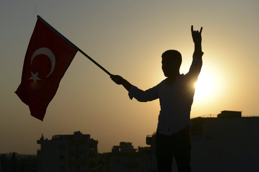 <p>A Turkish youth celebrates with a national flag after news about Syrian town of Tal Abyad, in Turkish border town of Akcakale, in Sanliurfa province, Sunday, Oct. 13, 2019. Turkey's official Anadolu news agency, meanwhile, said Turkey-backed Syrian forces have advanced into the center of a Syrian border town, Tal Abyad, on the fifth day of Turkey's military offensive. <strong>(Ismail Coskun/IHA via AP)</strong></p>