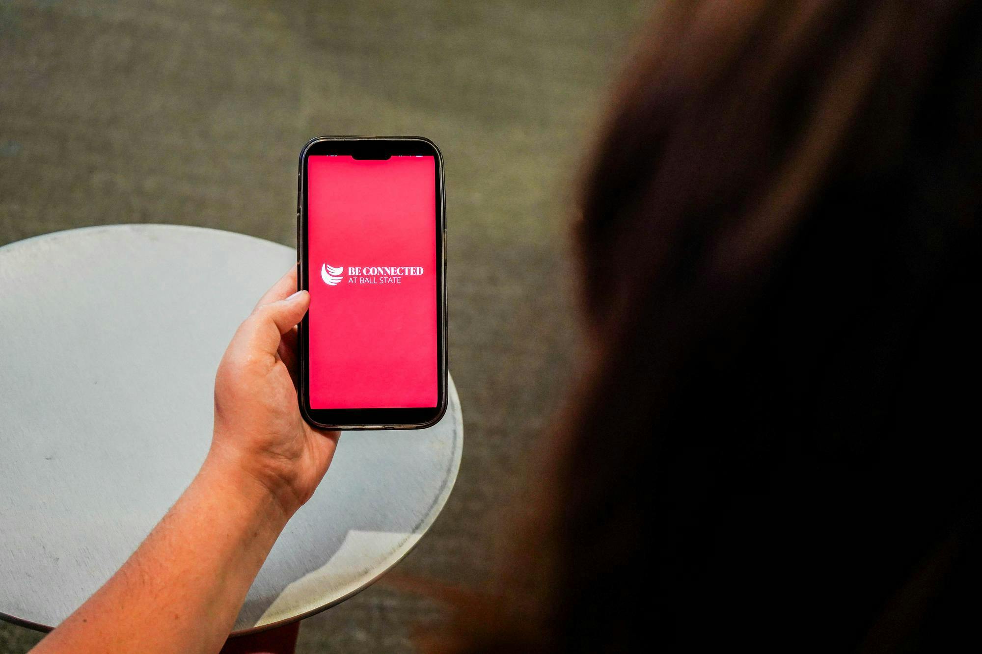 Ball State University student poses while opening the Be Connected app Sept. 8 in the Arts and Journalism Building. Isabella Kemper