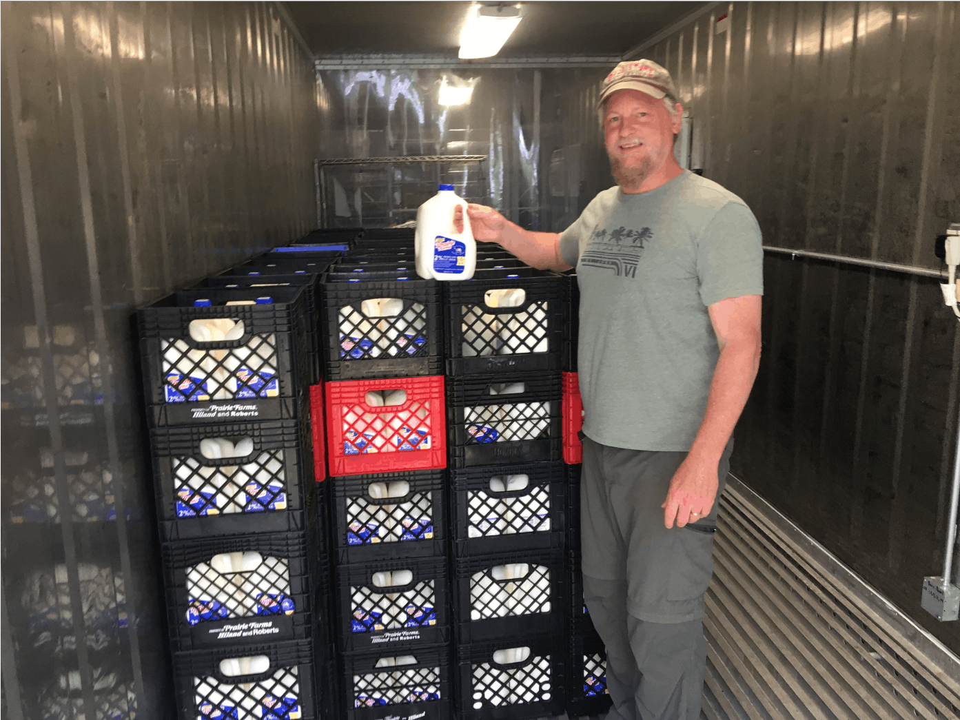 Joshua Gruver, associate professor of natural resources and environmental management poses with crates of milk provided by Prairie Farms in Anderson, Indiana. Through a collaboration between Muncie Food Hub Partnership and Delaware County Purdue Extension, he helped distribute thousands of gallons of milk in Delaware County. Joshua Gruver, Photo Provided