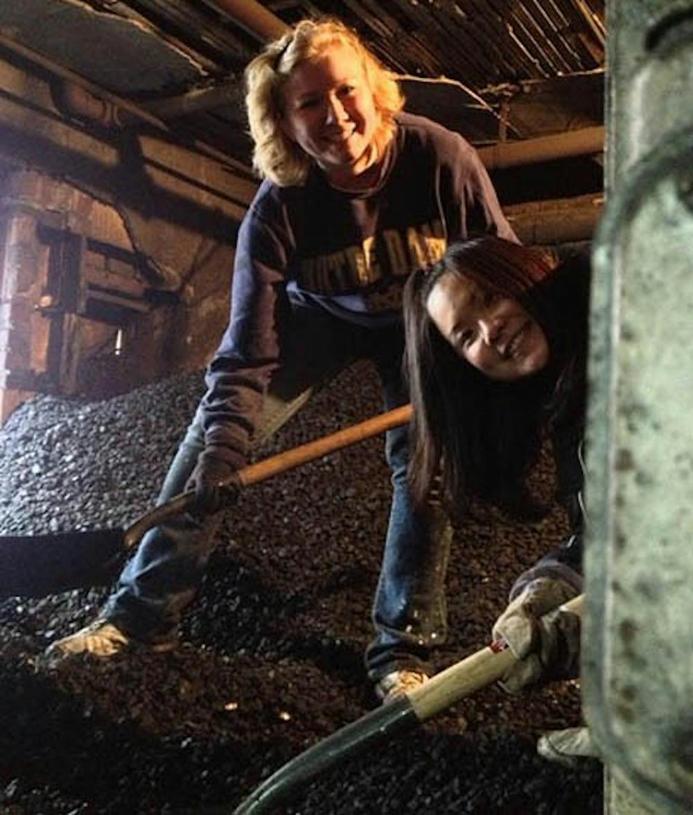 Elyse Brenner and Mayu Watanabe shovel $6,000 worth of coal into a furnace. This is the 10th year of Ball State’s Alternate Spring Break program. DN PHOTO CARIEMA WOOD
