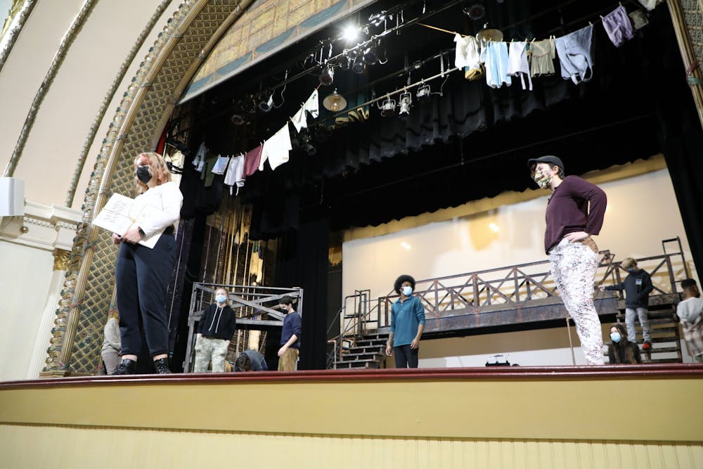 <p>Natalie Meyer, Ball State junior theatre creation major, holds a &quot;Newsies Banner&quot; onstage while listening to Brittany Covert, director of &quot;Newsies,&quot; alongside fellow cast members Feb. 8. &quot;Newsies&quot; is a musical loosely based on the newsboys&#x27; strike of 1899. Maya Wilkins, DN</p>