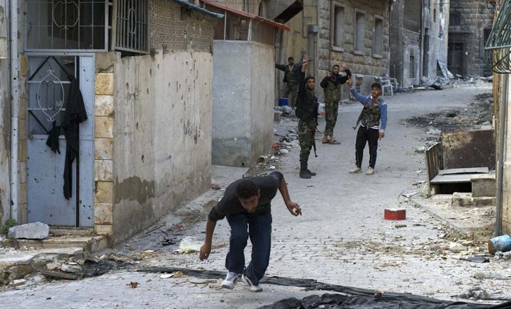 A Syrian civilian ducks and runs to avoid potential sniper fire in the old city of Aleppo, where rebels continue to battle the Syrian government, November 8, 2012. (David Enders/MCT)