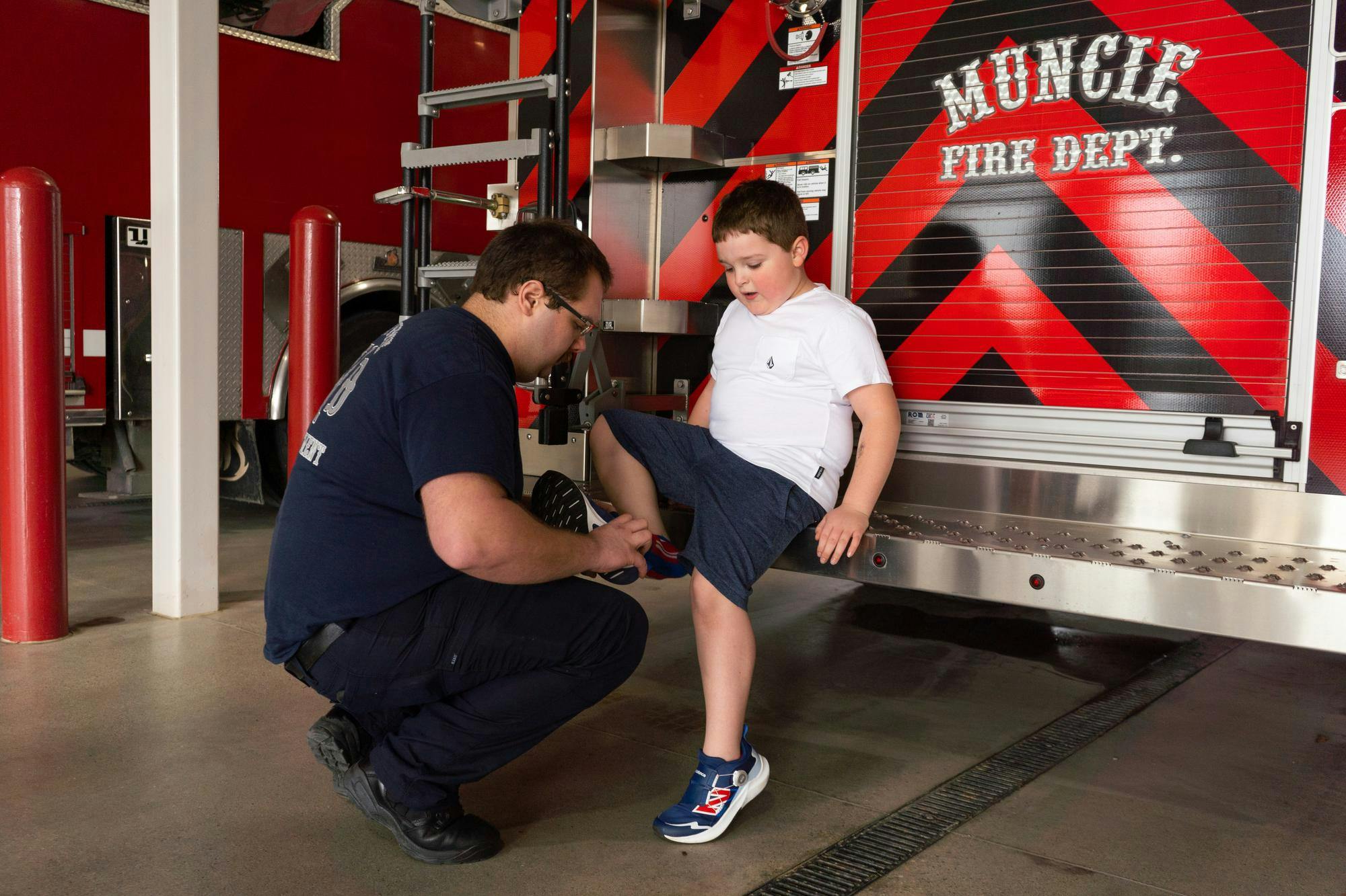 Brodrick Hendrickson ties his son Rhett Hendrickson’s shoe while he visits the station March 30 in Muncie, Indiana. Isabella Kemper, DN