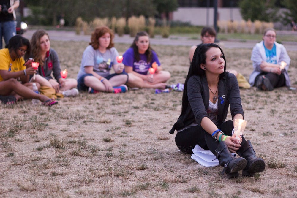 Carmen Diaz, a senior social work major, listens to a victims story at the Suicide Awareness Candlelight Vigil on Sept. 10. The vigil honored victims and survivors of suicide and those with depression. DN FILE PHOTO EMMA ROGERS 