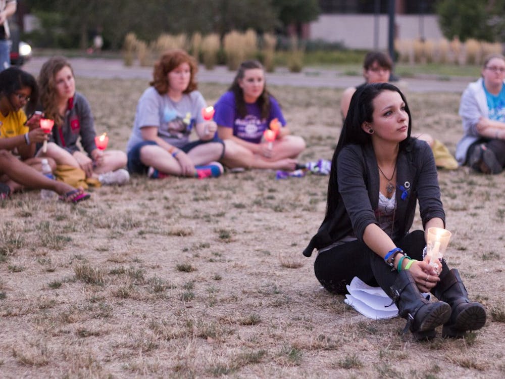 Carmen Diaz, a senior social work major, listens to a victims story at the Suicide Awareness Candlelight Vigil on Sept. 10. The vigil honored victims and survivors of suicide and those with depression. DN FILE PHOTO EMMA ROGERS