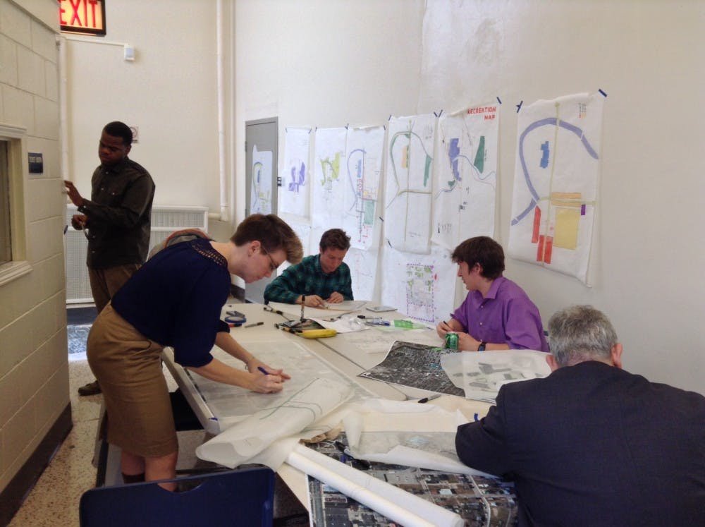 James Reinhart, an urban planning graduate student, works with his group in creating a proposal for expanding pedestrian travel routes to downtown Muncie for their Muncie Maker's District proposal. DN PHOTO ALAN HOVORKA