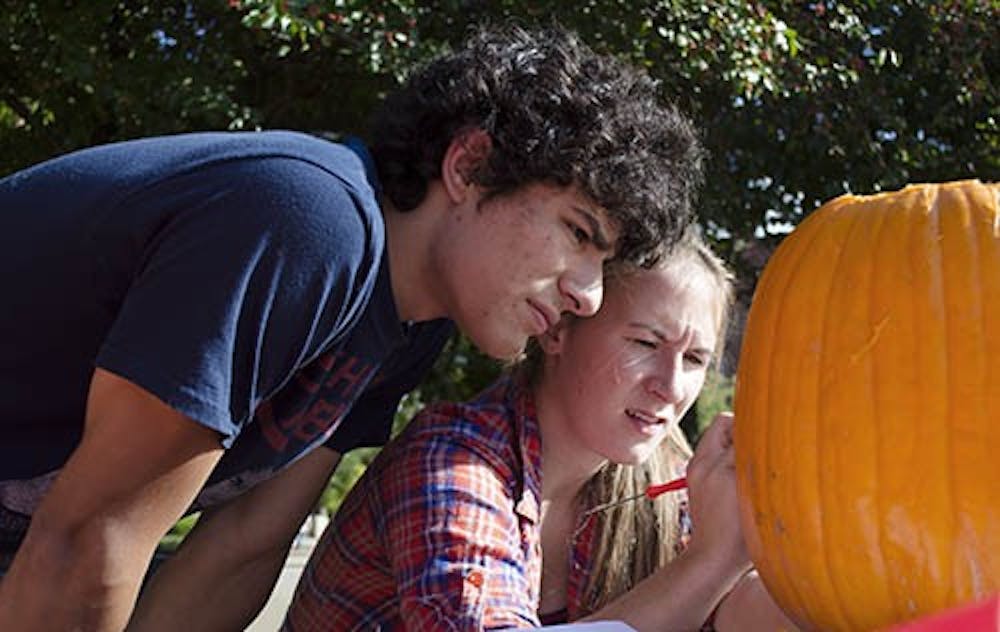Sophomore actuarial science major Ben Fehler and his teammate junior telecommunications major Jes Wade begin the details on their pumpkin during the pumpkin carving contest at Fall Fest on Oct. 4. Fehler and Wade won first place with their carving of Charmander from Pokemon. DN PHOTO BREANNA DAUGHERTY 