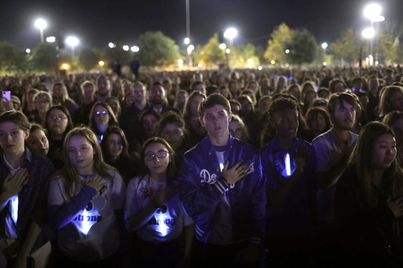 Students say the Pledge of Allegiance as thousands gather at a candlelight vigil for several students killed in the Saugus High School shooting in Central Park, Sunday, Nov. 17, 2019, in Santa Clarita, Calif. Detectives were searching for a motive for the killings carried out by the shooter on his 16th birthday. (Carolyn Cole/Los Angeles Times via AP)