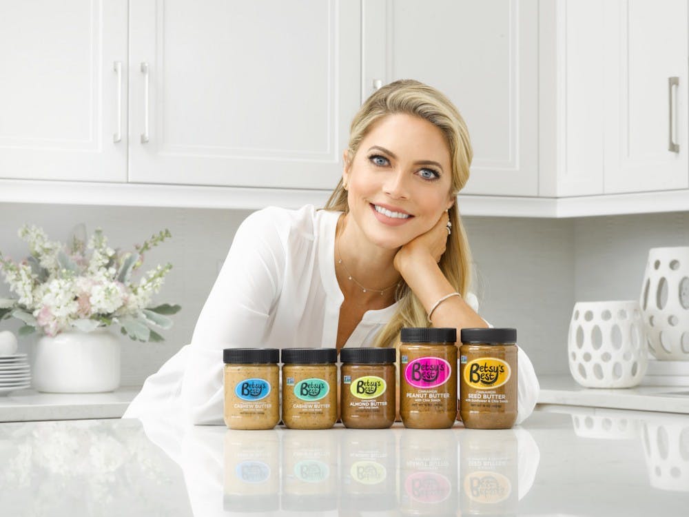 Alumna Betsy Opyt stands with the five nut butters she created in five years. Opyt opened Betsy's Best, her gourmet nut and seed butter company, after her daughter would not eat butters she brought home from the grocery store. Photo provided
