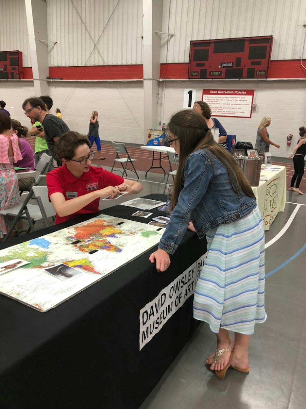 Senior Joan Seig explains the location and culture of a piece of art on Saturday, June 9, 2018 at Festival on the Green in Muncie, IN. Seig helped organized public outreach events throughout the summer as a program intern at the David Owsley Museum of Art. Photo provided. 
