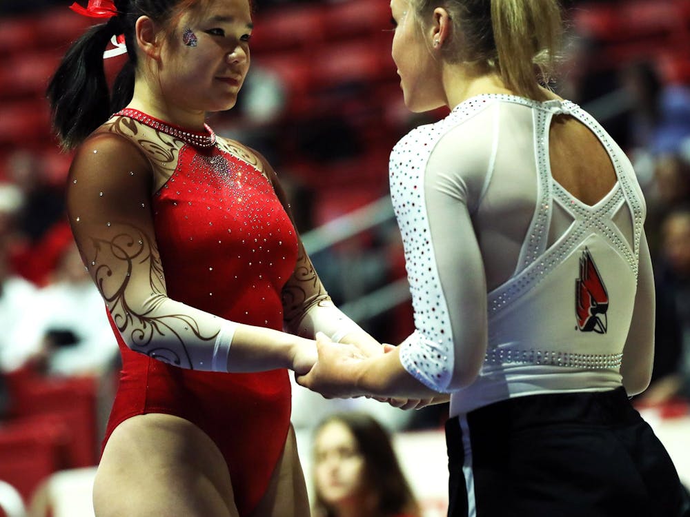 Freshman Delaney McMahon (left) gets a pep-talk from senior Hannah Ruthberg (right) during the Red vs White meet Dec. 8 at Worthen Arena. Mya Cataline, DN
