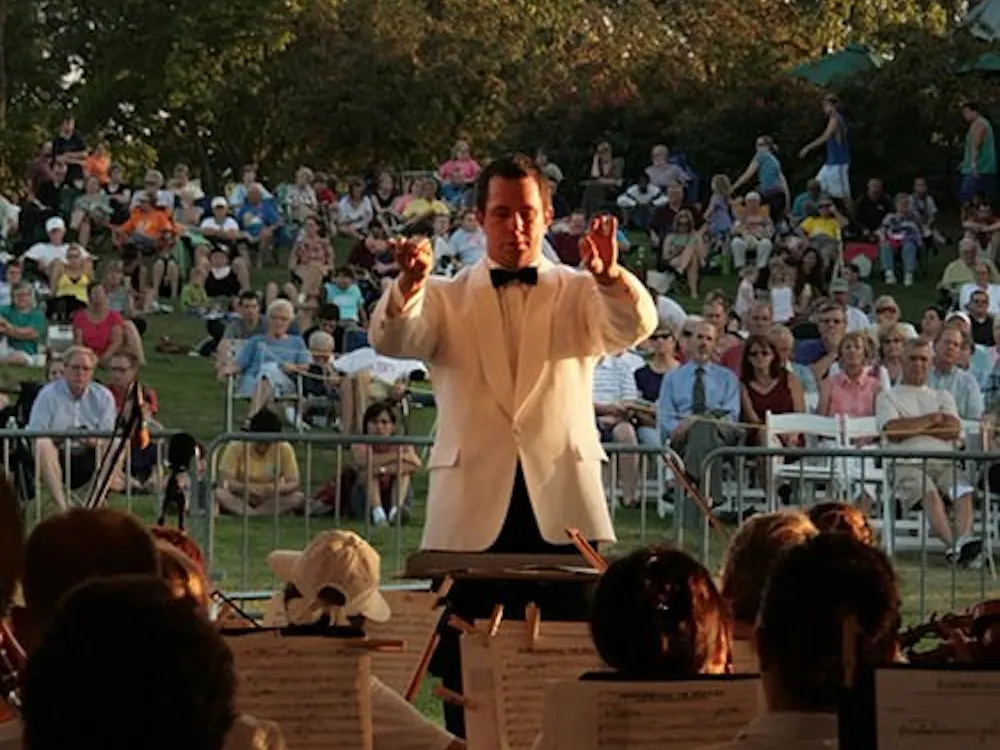 Conductor Douglas Droste directs the Muncie Symphony Orchestra in their final performance of the season at Minnetrista. The final concert called “Picnic & Pops” is a large draw for the community. DN PHOTO LOGAN WINSLOW