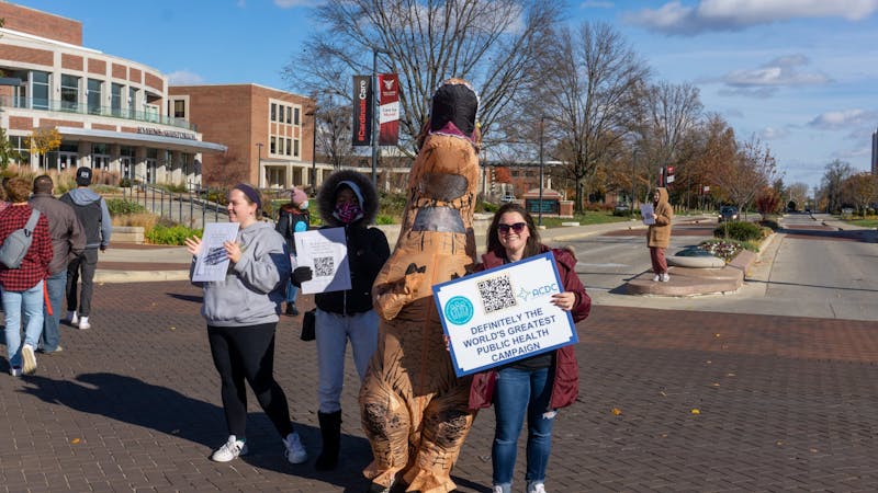 Students encourage pedestrians to check out the drug takeback event Nov. 18 at the Scramble Light. Organizers provided links to drug addiction resources via QR codes at the event. John Lynch, DN