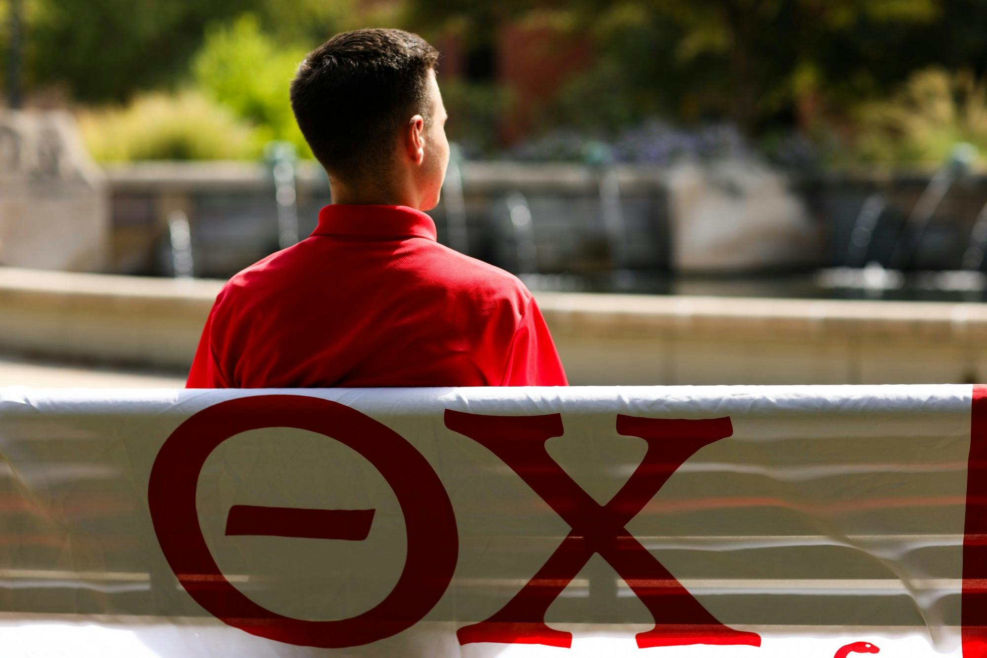 Second year meteorology and geoscience major Hunter Luzadder sits on a bench in front of Frog Baby Sept. 19. Jacy Bradley, DN
